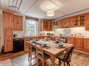 a kitchen with a wooden table and wooden cabinets at 4 Bed in Wylam 90433 in Wylam