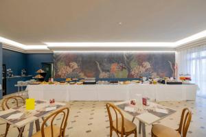 a dining room with tables and chairs and a buffet at Hotel Giancarlo in San Benedetto del Tronto
