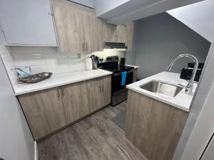 a small kitchen with a sink and a stove at Cute Highlandpark (Lower A Unit) in Calgary