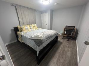 a bedroom with a bed and a chair in it at Cute Highlandpark (Lower A Unit) in Calgary
