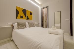 Un dormitorio blanco con una gran cama blanca. en Apt con estilo - 5pax en zona Tirso-Centro, en Madrid