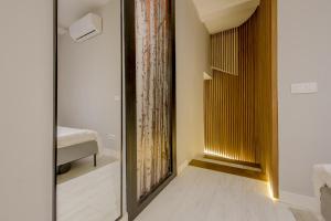 pasillo con espejo y cama en la habitación en Apt con estilo - 5pax en zona Tirso-Centro, en Madrid