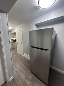 a kitchen with a stainless steel refrigerator in a room at Cute Highlandpark (Lower A Unit) in Calgary