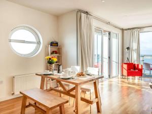 a living room with a table and a red chair at 2 bed in Brightlingsea 90382 in Saint Osyth