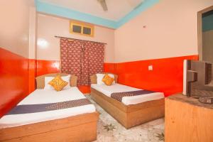 Habitación con 2 camas y TV. en OYO Hotel Chitra, en Alīpur Duār