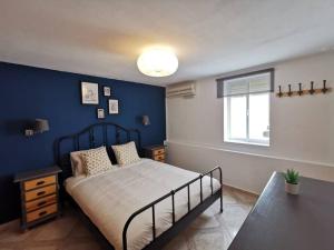 a bedroom with a bed and a blue wall at CDZ - Arteaga- two rooms with queen bed in Cádiz