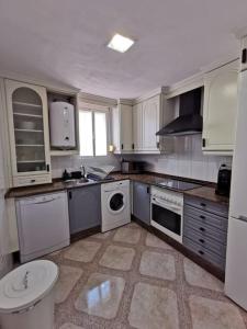 a kitchen with white cabinets and a washer and dryer at CDZ - Arteaga- two rooms with queen bed in Cádiz