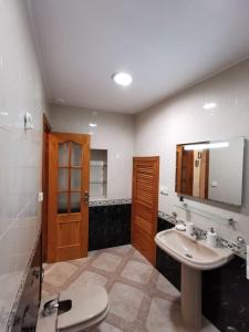 a bathroom with a toilet and a sink and a mirror at CDZ - Arteaga- two rooms with queen bed in Cádiz