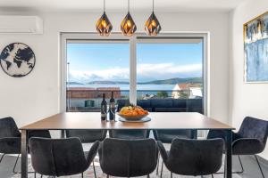 a dining room with a table and chairs and a large window at Apartments Velic in Brodarica