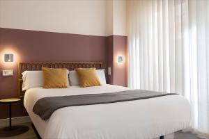 ein Schlafzimmer mit einem großen Bett und einem Fenster in der Unterkunft Espíritu Santo Suite Apartment in Sevilla