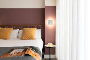 ein Schlafzimmer mit einem Bett mit einem Buch darauf in der Unterkunft Espíritu Santo Suite Apartment in Sevilla