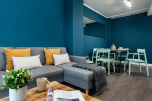ein Wohnzimmer mit einem Sofa und einer blauen Wand in der Unterkunft Espíritu Santo Suite Apartment in Sevilla