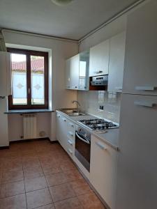 a kitchen with white cabinets and a stove top oven at IRIS Intero appartamento piano terra in Cavaria +8 photos