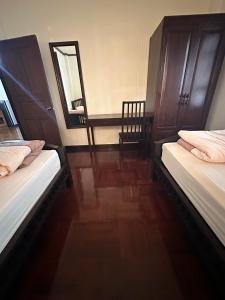 2 camas sentadas en una habitación con espejo en SJ house Unique wood Thai style, en Chiang Mai