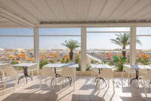 a patio with tables and chairs and a view of the ocean at Hotel Giancarlo in San Benedetto del Tronto