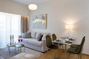 sala de estar con sofá y mesa con sillas en La Residence Athens M2 & M3, en Atenas