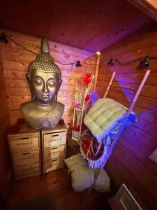 Habitación con cama y una gran estatua de Buda en La bulle à bonheur - Spa privatif 
