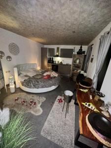 a bedroom with a large bed and a bathroom at La bulle à bonheur - Spa privatif 