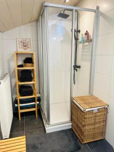 a shower stall in a bathroom with a basket at L'inspiration in Stavelot