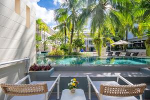 a resort with a swimming pool and two chairs at A2 Pool Resort, Phuket Town - scheduled shuttle to Phuket Old Town in Phuket