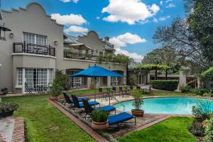 an exterior view of a house with a pool and patio furniture at Clico Boutique Hotel in Johannesburg