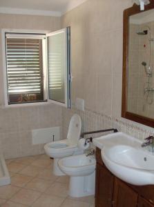 Nel Salento, vicino Gallipoli في أليزيو: حمام مع مرحاض ومغسلة ومرآة