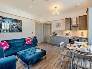 uma sala de estar com um sofá azul e uma cozinha em 2 Bed in Arnside 90408 em Arnside