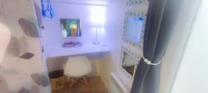 Habitación blanca con silla blanca y lámpara en EntreLac&Océan chambre d'hôtes chez l'habitant 2, cyclotouriste bienvenue, en Aureilhan