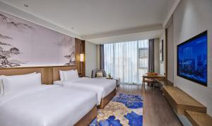 Cette chambre comprend 2 lits et une télévision à écran plat. dans l'établissement Crowne Plaza Chengdu Wuhou, an IHG Hotel, à Chengdu