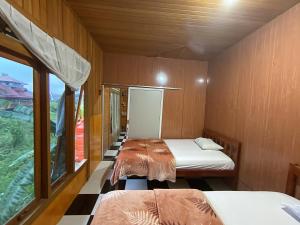 een kleine kamer met 2 bedden en een raam bij THE SINGKI HOME FAMILY in Rantepao