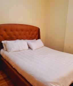 a bed with two white pillows on top of it at Rossyln Home close to UN, Village Market and Two Rivers Mall in Nairobi