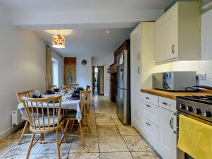 uma cozinha com uma mesa e cadeiras numa cozinha em 5 Bed in Swanage 90502 em Swanage