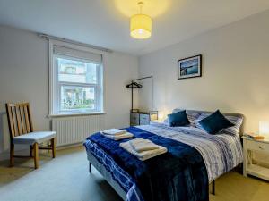 um quarto com uma cama, uma cadeira e uma janela em 5 Bed in Swanage 90502 em Swanage
