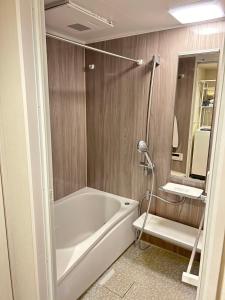 y baño con bañera blanca y espejo. en tokyo tower N&F, en Tokio