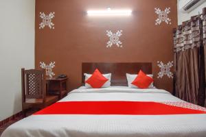 a bedroom with a bed with red and white pillows at OYO Hotel Shiv Shakti in Jaipur