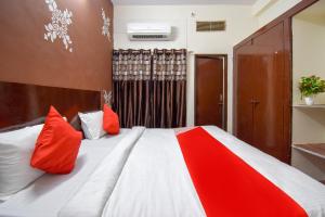 a bedroom with a bed with red and white pillows at OYO Hotel Shiv Shakti in Jaipur
