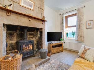 a living room with a fireplace and a tv at 1 Bed in Matlock 90487 in Matlock