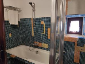 a bathroom with a tub and a shower with a window at Casa del Arte in Simancas