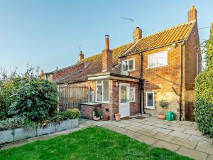 a brick house with a garden in front of it at 2 Bed in Great Walsingham 90535 in Little Walsingham