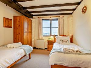 1 dormitorio con 2 camas y ventana en 2 Bed in Dulverton 90558, en Dulverton