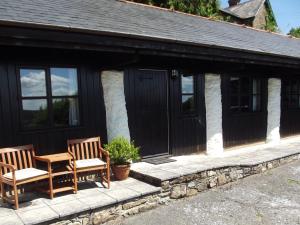 two chairs and a table in front of a cottage at 2 Bed in Dulverton 90558 in Dulverton
