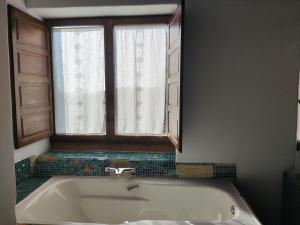 a bath tub in a bathroom with a window at Casa del Arte in Simancas