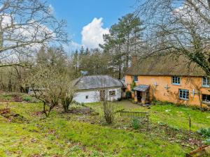 an old house with a thatched roof in a field at 1 Bed in Tiverton 90656 in Washfield