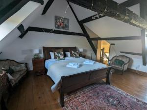 a bedroom with a large bed and a couch at Canons Court Lodge in Wotton-under-Edge