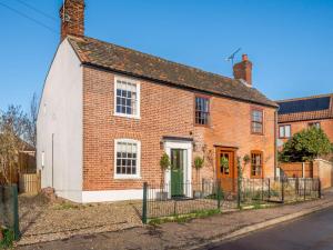 a brick house with a green door on a street at 2 Bed in Foulsham 90675 in Foulsham