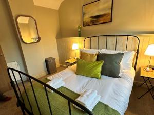 a bedroom with a bed with green and white pillows at 1 Bed in Fakenham 90683 in Fakenham