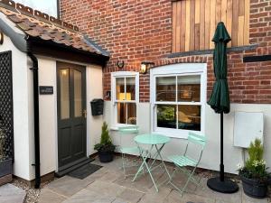 a patio with a table and an umbrella and a building at 1 Bed in Fakenham 90683 in Fakenham