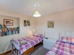 a bedroom with two beds and a book shelf at 3 Bed in Bishops Castle 90644 in Bishops Castle