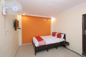 een slaapkamer met een bed met een oranje muur bij OYO Hotel Vn Residency in Jabalpur