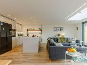 a living room with a blue couch and a kitchen at 3 bed property in Holsworthy 90721 in Holsworthy